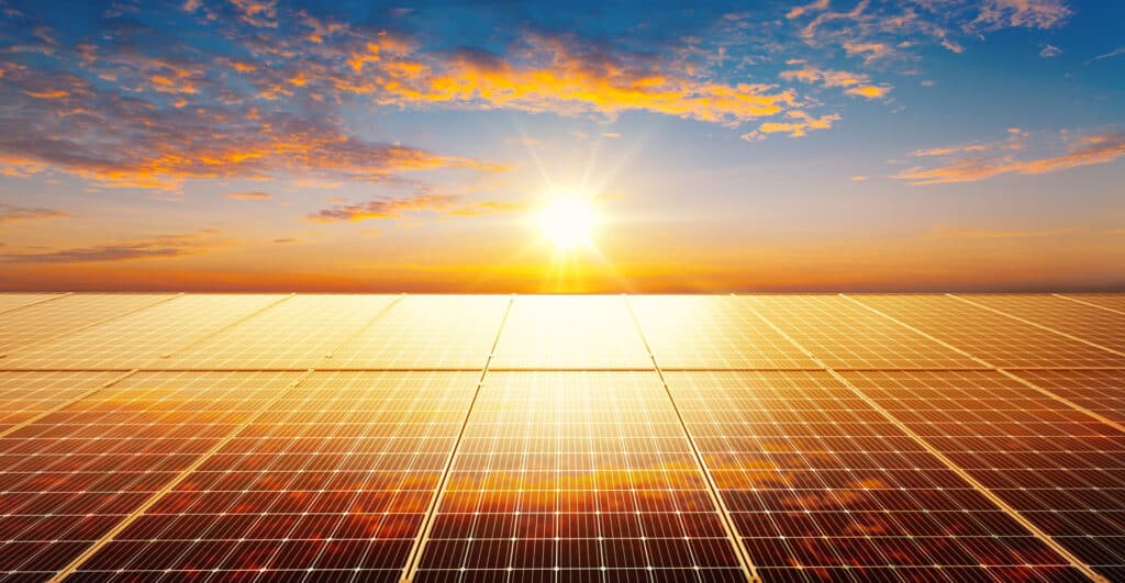 Solar panels on roof with sunset in the back